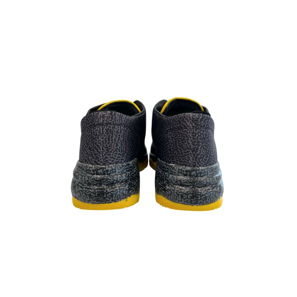 Borbonese black leather sneakers with grey animal print detailing and bright yellow soles, back view.