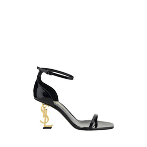 Saint Laurent black patent calf leather stiletto sandals with gold-tone YSL monogram logo heel and ankle strap.