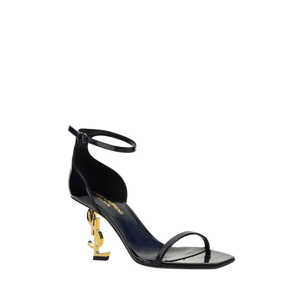 Saint Laurent black patent calf leather stiletto sandal with iconic YSL gold-tone logo heel and ankle strap.