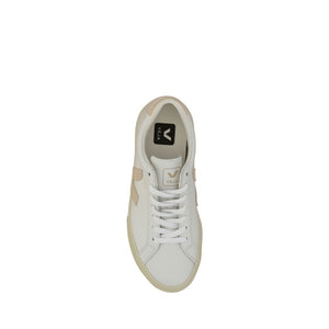 Top-down view of a white low-top leather sneaker with beige accents and white laces.