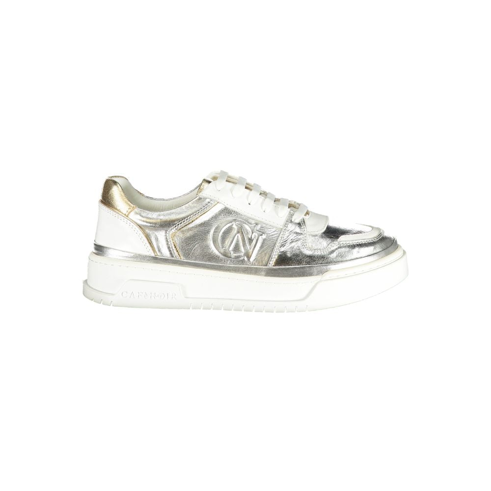Female model wearing Cafenoir silver and gold metallic crinkled leather lace-up sneakers with an embossed CN logo, gold heel counter, white laces, and white chunky platform sole, captured mid-step in a casual lifestyle pose showcasing the shoe's glamorous metallic profile and luxe detailing.