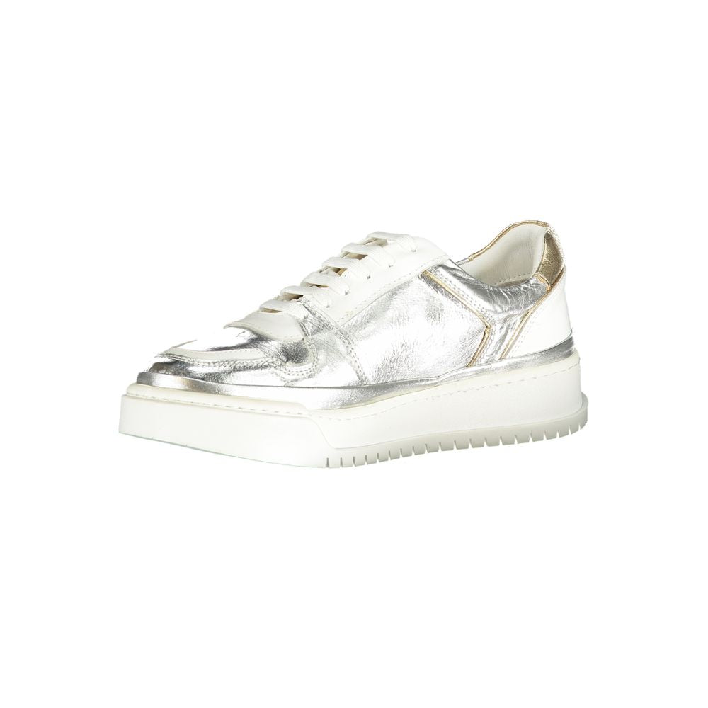 Female model wearing Cafenoir silver and gold metallic crinkled leather lace-up sneakers with an embossed CN logo, gold heel counter, white laces, and white chunky platform sole, captured mid-step in a casual lifestyle pose showcasing the shoe's glamorous metallic profile and luxe detailing.