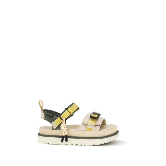 UGG beige and olive green flat sport sandals with yellow nylon straps, black buckles, and a thick platform sole.