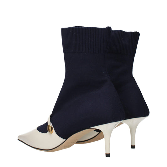 Jimmy Choo navy blue knit ankle boots with white pointed toe, kitten heel, and gold-tone side hardware detail.