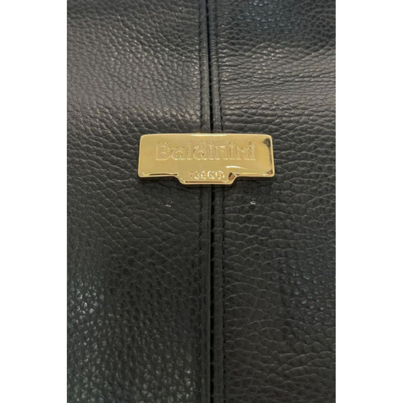 Black textured leather bag detail with gold metal brand logo plate