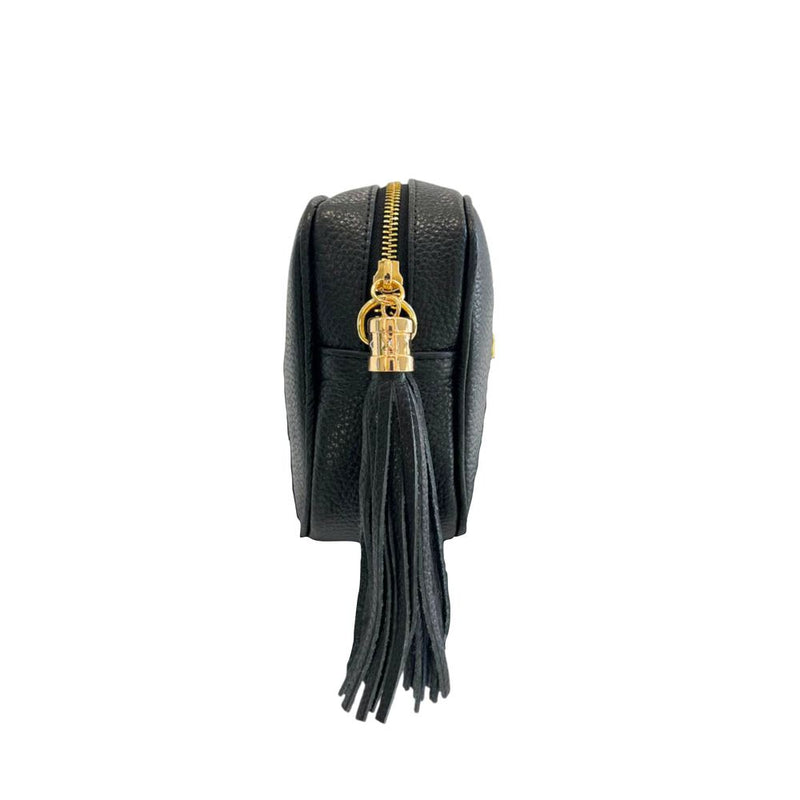 Black textured leather crossbody bag side view with a gold zipper and tassel