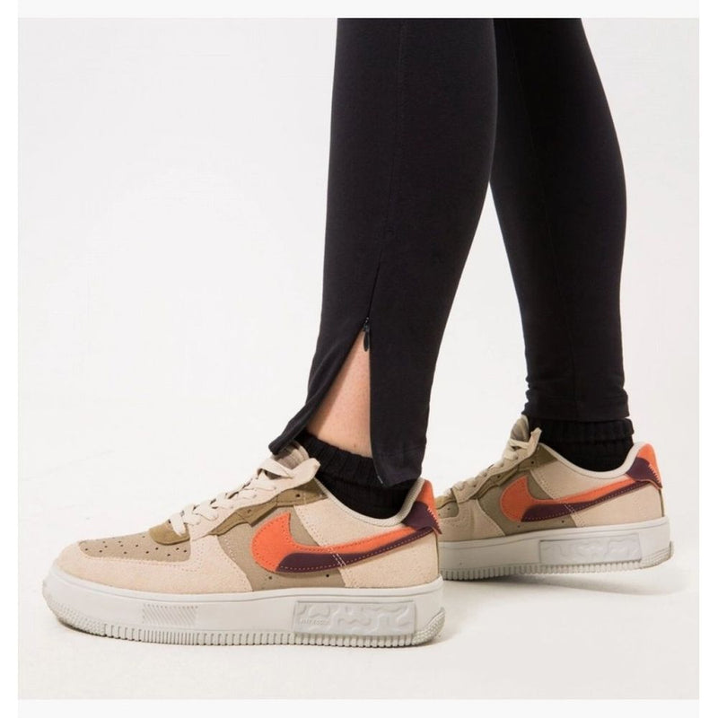 Black cotton ankle-slit leggings worn with beige sneakers