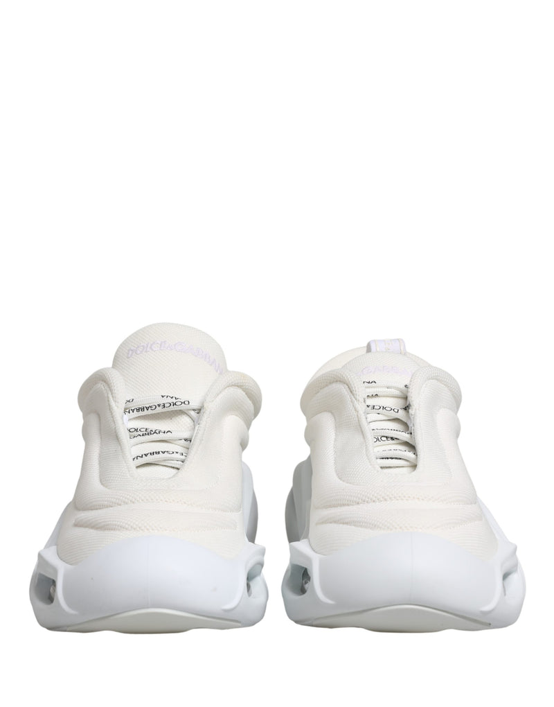 White Dolce & Gabbana low-top slip-on sneakers with a chunky wave-shaped rubber sole and textured mesh fabric upper.