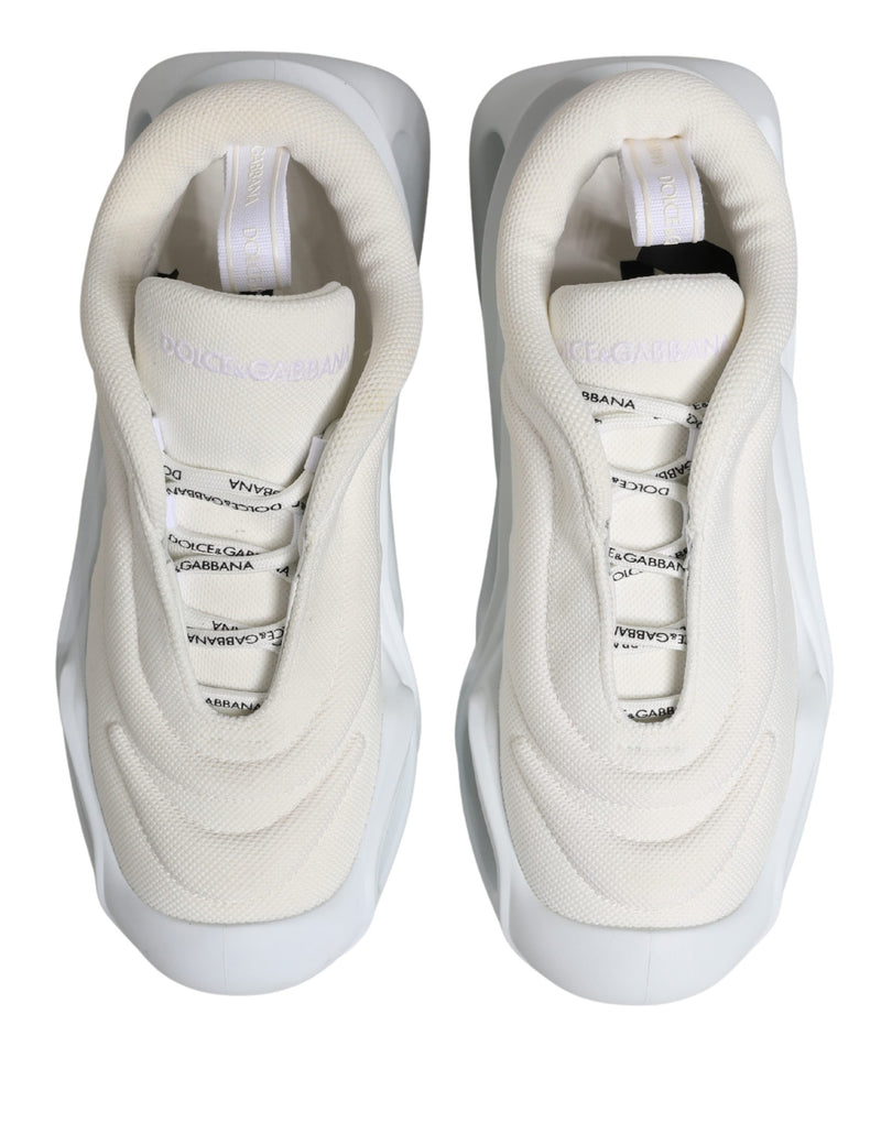 Dolce & Gabbana white mesh low-top sneakers with a wavy rubber sole, slip-on style, and branded ribbon details.
