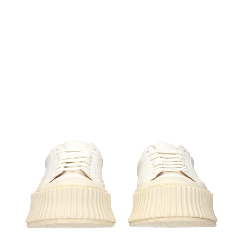 White leather platform sneakers with thick ridged rubber soles and lace-up fronts
