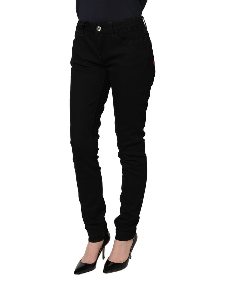 Black skinny denim jeans worn by a model in black heels
