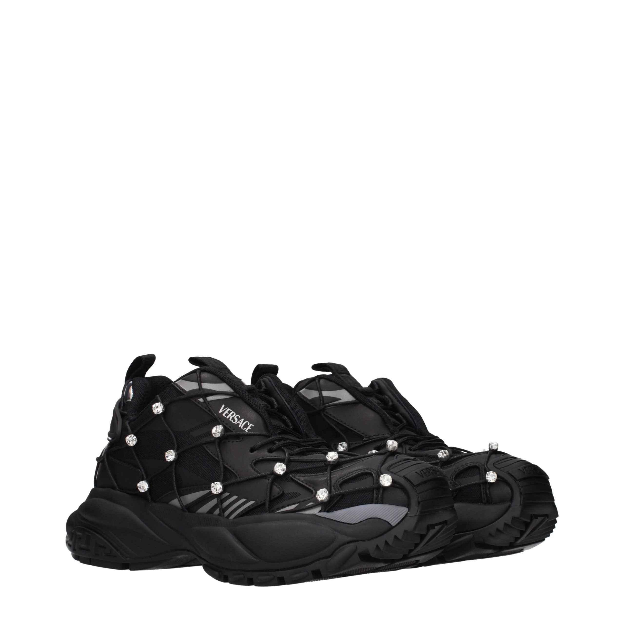 Versace black chunky sneakers in mesh and fabric, featuring crystal-studded cage overlays and thick, sculpted soles.