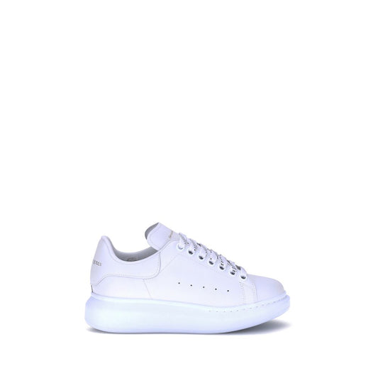 Female model wearing Alexander McQueen white calf leather Bos Taurus platform sneakers with a clean white upper, premium leather finish, and signature oversized chunky sole, captured mid-step in a casual lifestyle pose showcasing the shoe's iconic silhouette and luxurious detailing.