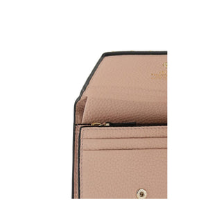 Close-up of pink grained calf leather wallet interior with card slots and snap button.