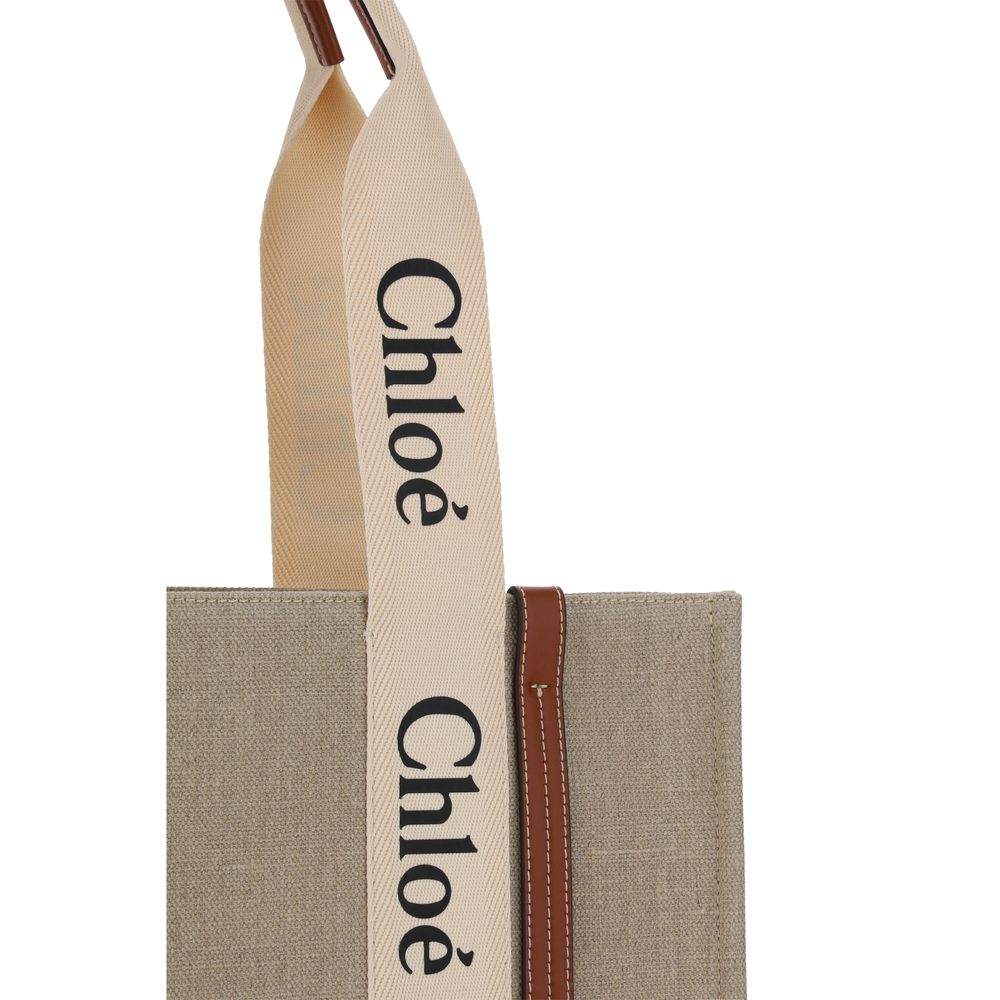 Chloé beige linen handbag featuring wide cream straps with black logo print and brown leather trim.