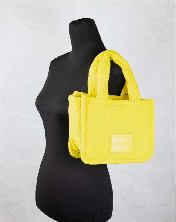 Golden kiwi terry cloth Marc Jacobs tote bag on shoulder of black mannequin