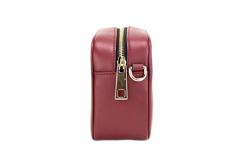 Side view of a pomegranate smooth leather crossbody camera bag with gold zipper and hardware