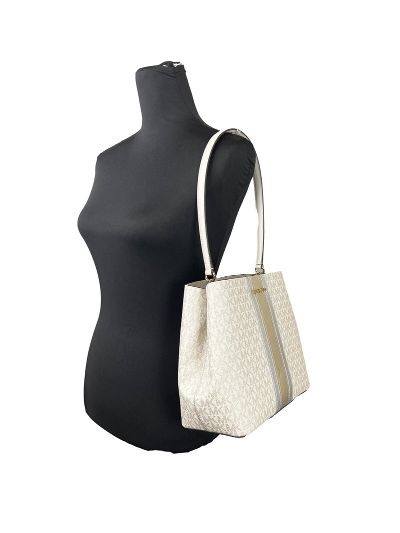 Michael Kors white and beige monogram bucket shoulder bag on a mannequin