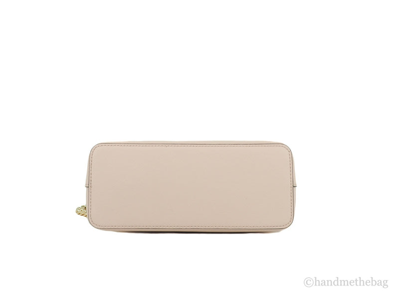 Bottom view of a pale pink leather dome crossbody bag with gold hardware