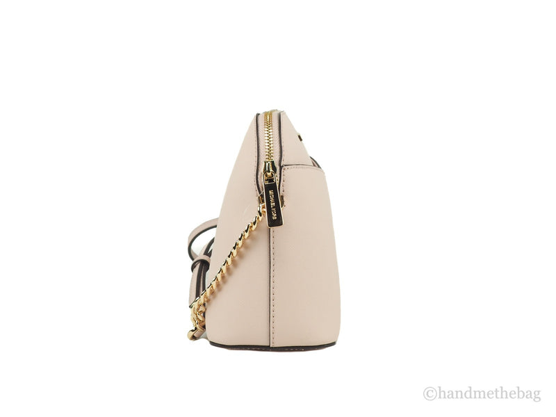 Side view of a light pink leather dome crossbody bag with gold hardware