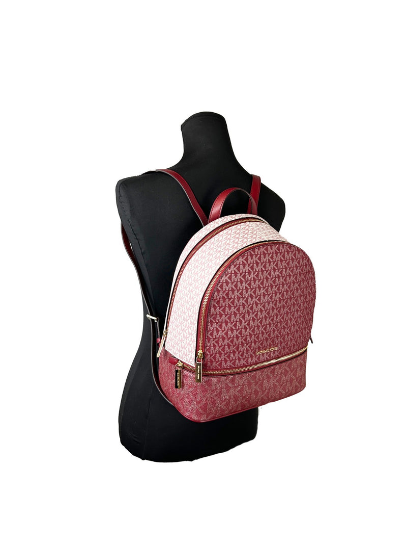 Red and pink MK monogram PVC backpack with gold zippers worn on a black mannequin