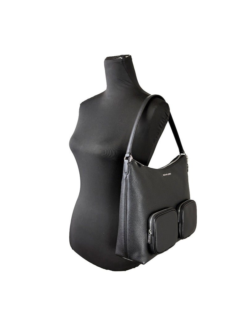 Black pebbled leather shoulder bag with two front cargo pockets on a black mannequin