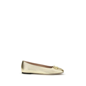 Metallic gold napa leather ballet flats by Valentino Garavani with a round toe and gold VLOGO hardware.