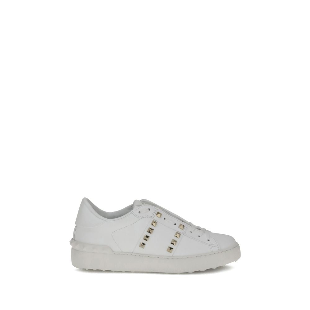 White calf leather low-top sneakers with gold-tone pyramid studs and matching white rubber soles.