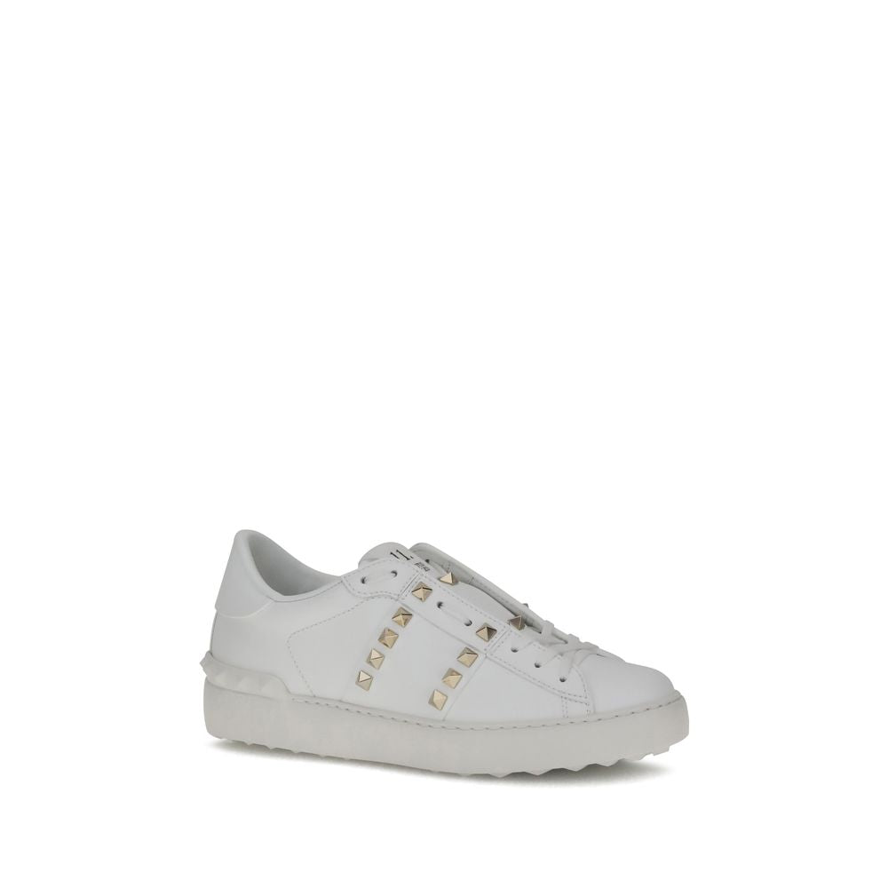 White smooth leather low-top sneaker featuring gold-tone pyramid studs and a thick, tonal rubber sole.