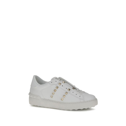 White smooth leather low-top sneaker featuring gold-tone pyramid studs and a thick, tonal rubber sole.