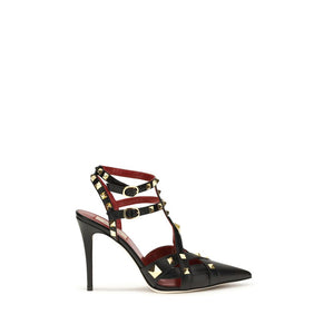 Black goatskin stiletto pump with gold studs, red lining, and double buckled ankle straps.