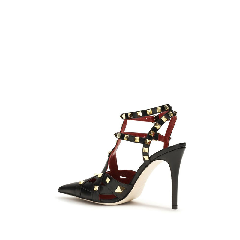Black goatskin high-heel pump with strappy caged design and signature gold-tone pyramid studs.