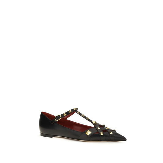 Female model wearing Valentino Garavani black goatskin ballet flats with a luxurious black goatskin upper, delicate flat silhouette, and signature Valentino Garavani detailing, captured mid-step in a casual lifestyle pose showcasing the flat's refined elegance and iconic Italian luxury craftsmanship.