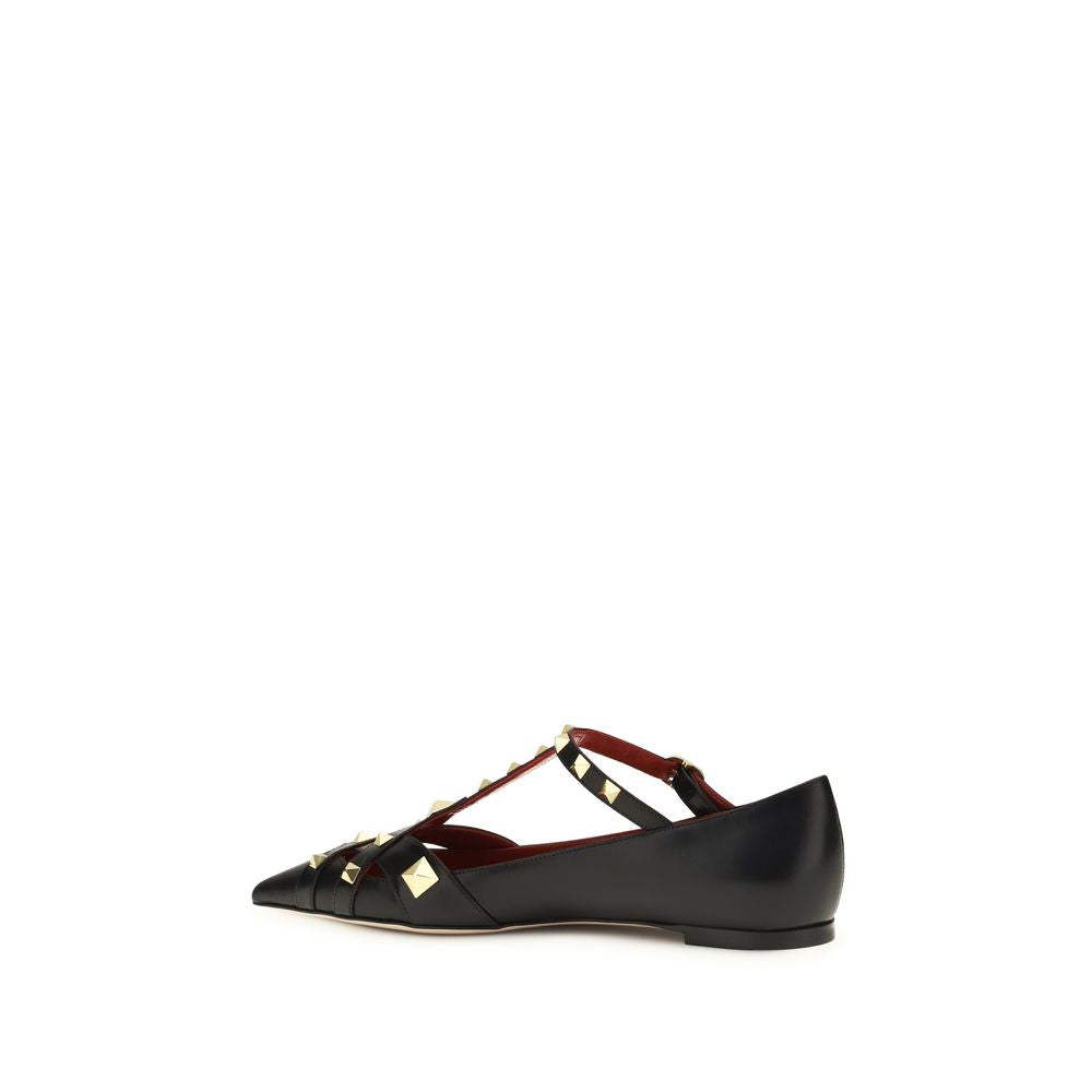 Female model wearing Valentino Garavani black goatskin ballet flats with a luxurious black goatskin upper, delicate flat silhouette, and signature Valentino Garavani detailing, captured mid-step in a casual lifestyle pose showcasing the flat's refined elegance and iconic Italian luxury craftsmanship.