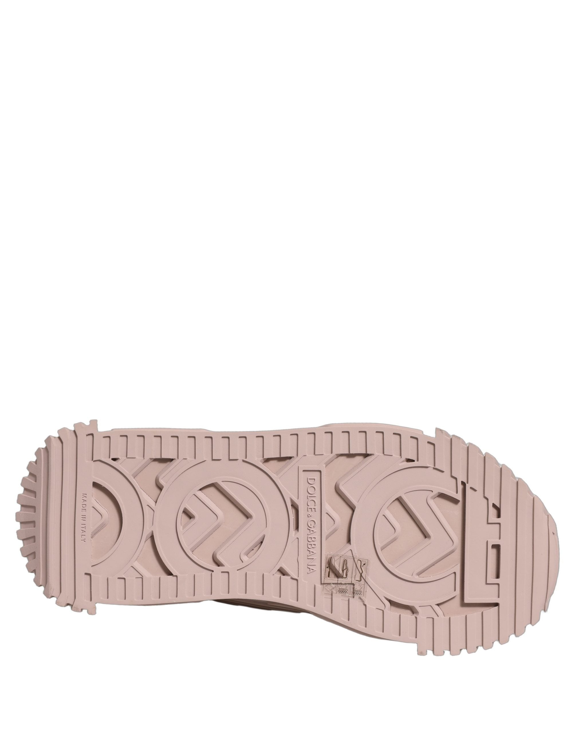 Pink rubber sneaker sole with a tread pattern featuring embossed Dolce & Gabbana logo lettering.