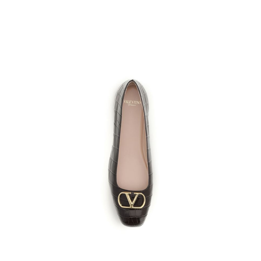 Female model wearing Valentino Garavani brown calf leather ballet flats with a rich brown calf leather upper, delicate flat silhouette, and signature Valentino Garavani detailing, captured mid-step in a casual lifestyle pose showcasing the flat's refined elegance and iconic Italian luxury craftsmanship.