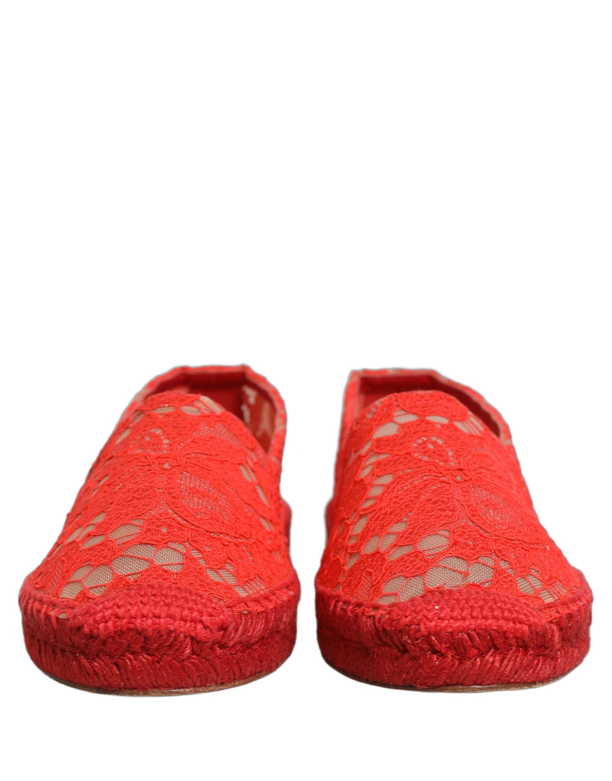 Female model wearing vibrant red floral lace espadrille slip-on shoes with a sheer lace overlay, rope-stitched espadrille sole, and bold red colourway, captured mid-step in a casual lifestyle pose showcasing the shoe's elegant profile and delicate lace detailing.