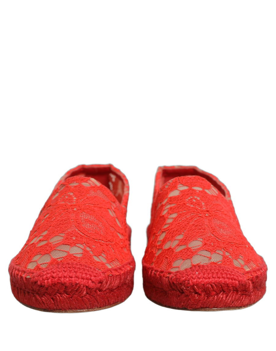 Female model wearing vibrant red floral lace espadrille slip-on shoes with a sheer lace overlay, rope-stitched espadrille sole, and bold red colourway, captured mid-step in a casual lifestyle pose showcasing the shoe's elegant profile and delicate lace detailing.