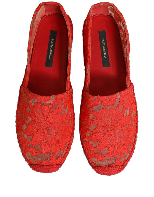 Female model wearing vibrant red floral lace espadrille slip-on shoes with a sheer lace overlay, rope-stitched espadrille sole, and bold red colourway, captured mid-step in a casual lifestyle pose showcasing the shoe's elegant profile and delicate lace detailing.