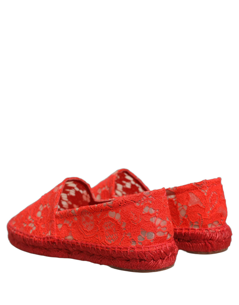 Female model wearing vibrant red floral lace espadrille slip-on shoes with a sheer lace overlay, rope-stitched espadrille sole, and bold red colourway, captured mid-step in a casual lifestyle pose showcasing the shoe's elegant profile and delicate lace detailing.