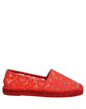 Female model wearing vibrant red floral lace espadrille slip-on shoes with a sheer lace overlay, rope-stitched espadrille sole, and bold red colourway, captured mid-step in a casual lifestyle pose showcasing the shoe's elegant profile and delicate lace detailing.