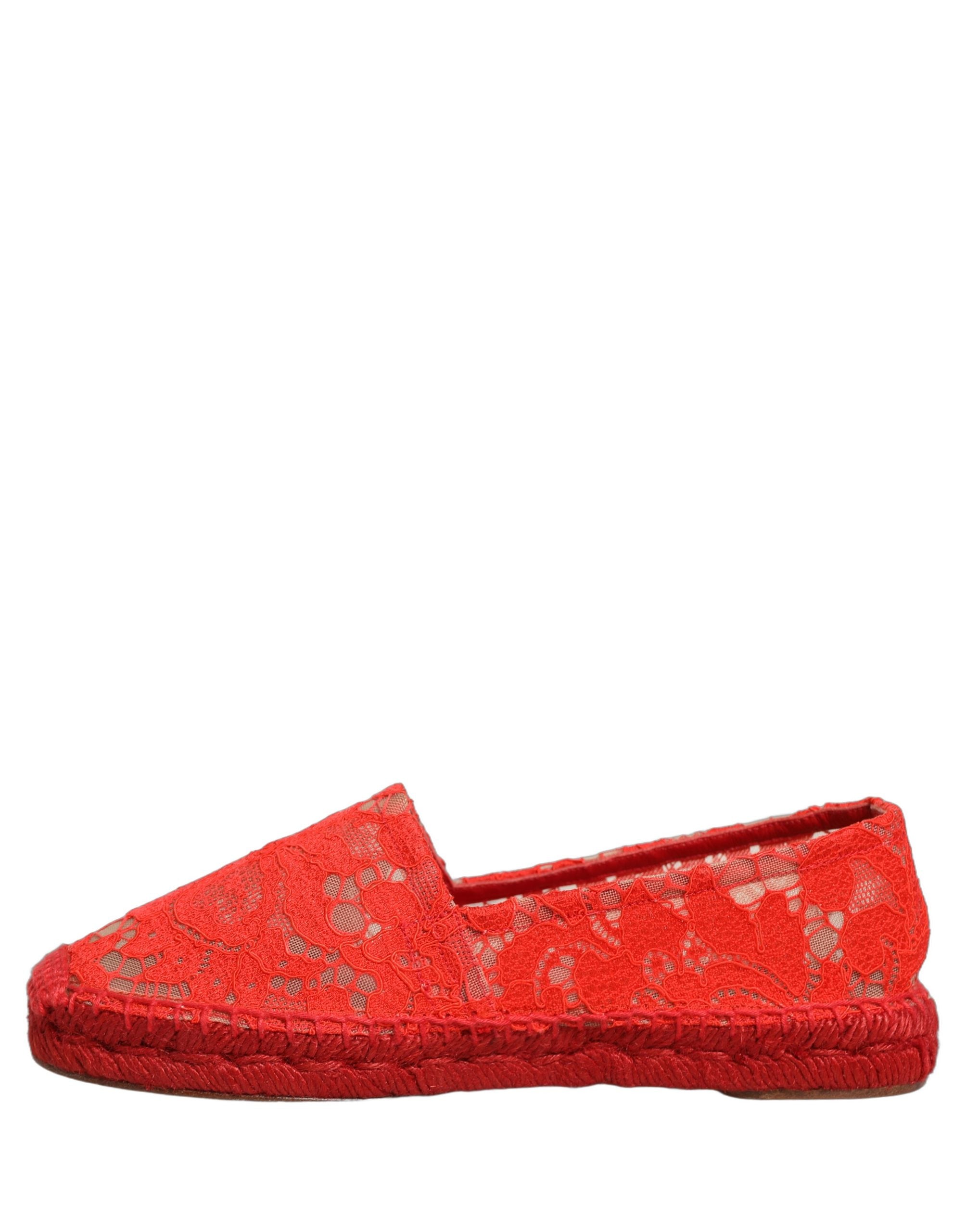 Female model wearing vibrant red floral lace espadrille slip-on shoes with a sheer lace overlay, rope-stitched espadrille sole, and bold red colourway, captured mid-step in a casual lifestyle pose showcasing the shoe's elegant profile and delicate lace detailing.