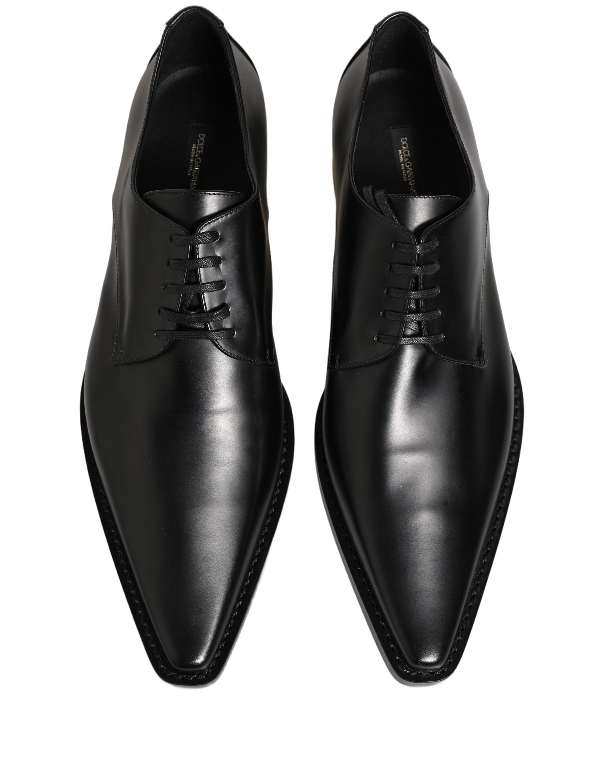 Female model wearing sleek black polished leather Derby shoes with a square toe, clean lace-up front, structured block heel, and high-gloss finish, captured mid-step in a casual lifestyle pose showcasing the shoe's sharp profile and sophisticated silhouette.