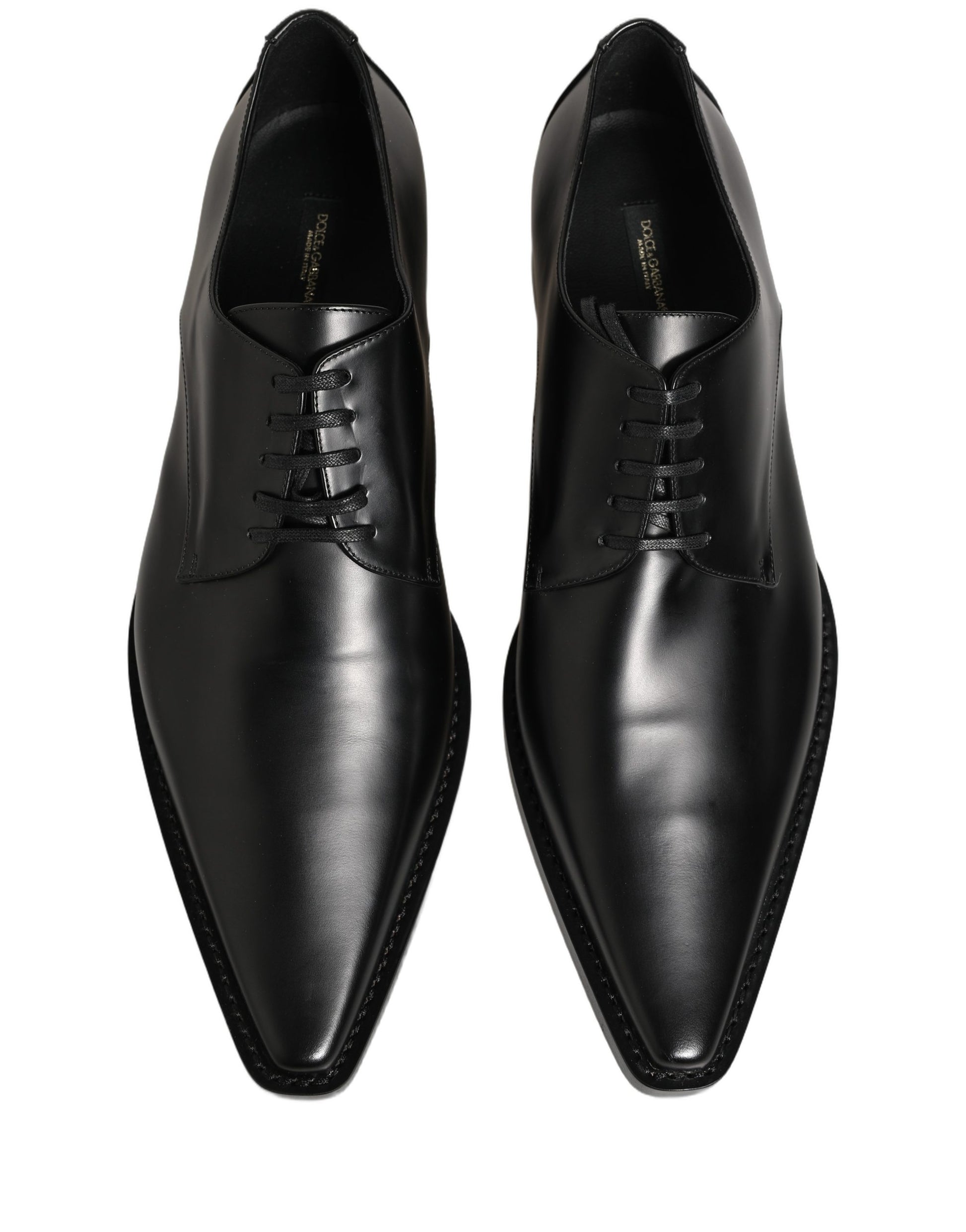 Female model wearing sleek black polished leather Derby shoes with a square toe, clean lace-up front, structured block heel, and high-gloss finish, captured mid-step in a casual lifestyle pose showcasing the shoe's sharp profile and sophisticated silhouette.