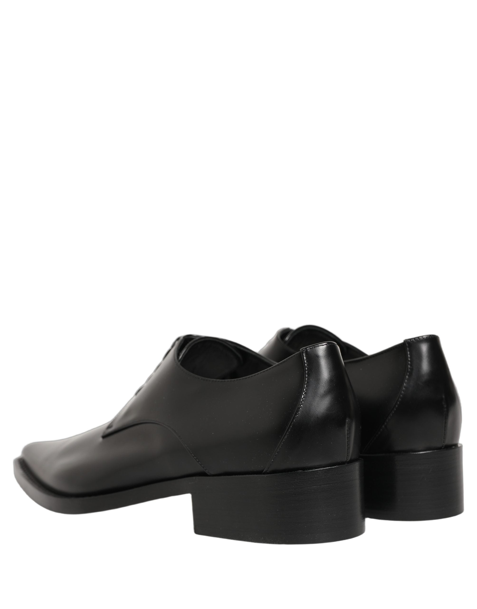 Female model wearing sleek black polished leather Derby shoes with a square toe, clean lace-up front, structured block heel, and high-gloss finish, captured mid-step in a casual lifestyle pose showcasing the shoe's sharp profile and sophisticated silhouette.