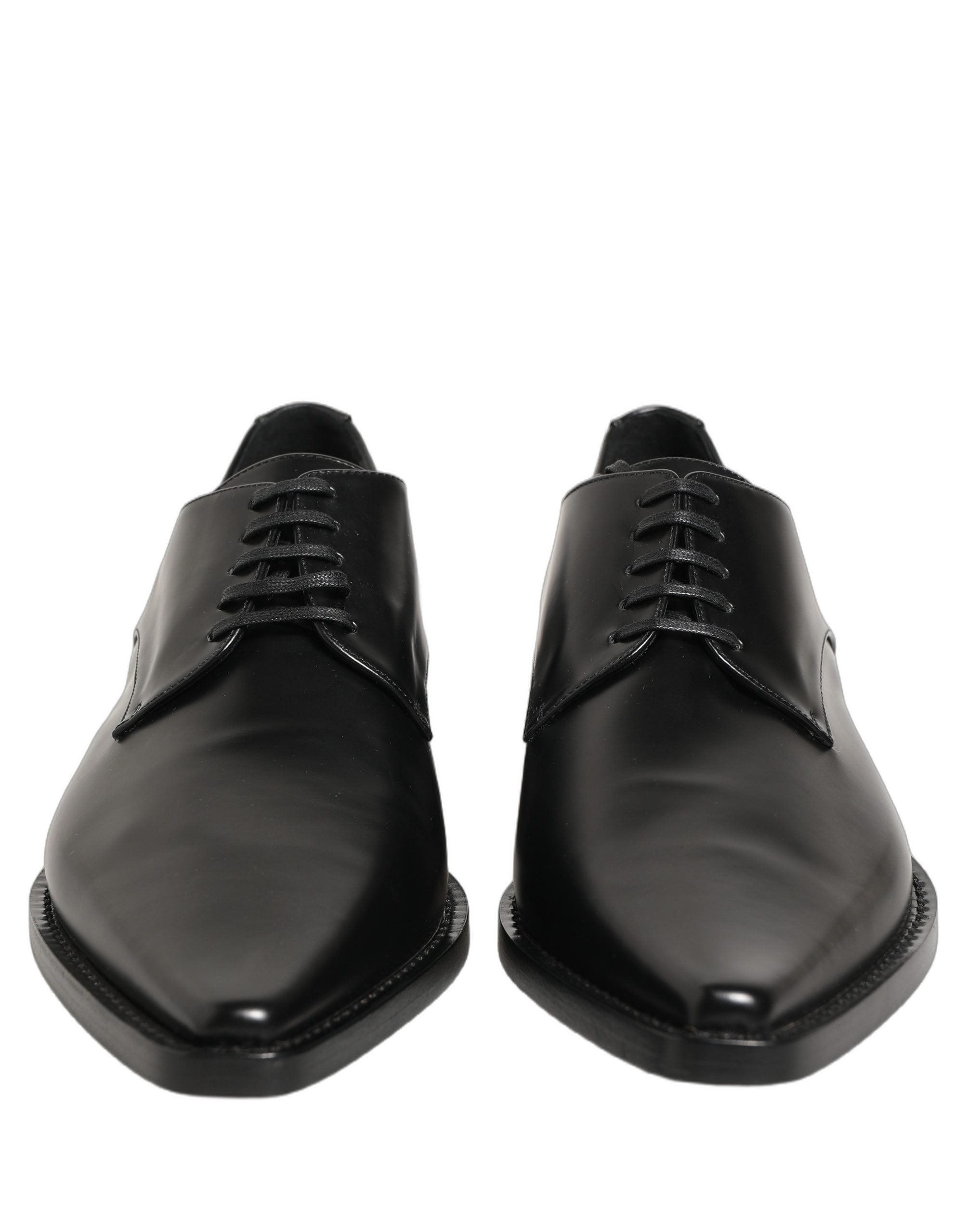 Female model wearing sleek black polished leather Derby shoes with a square toe, clean lace-up front, structured block heel, and high-gloss finish, captured mid-step in a casual lifestyle pose showcasing the shoe's sharp profile and sophisticated silhouette.