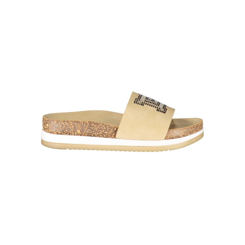 Female model wearing Laura Biagiotti beige polyurethane women's slipper with a warm beige upper, effortless slip-on silhouette, and refined Italian craftsmanship, captured mid-step in a casual lifestyle pose showcasing the slipper's relaxed neutral charm and understated everyday luxury.