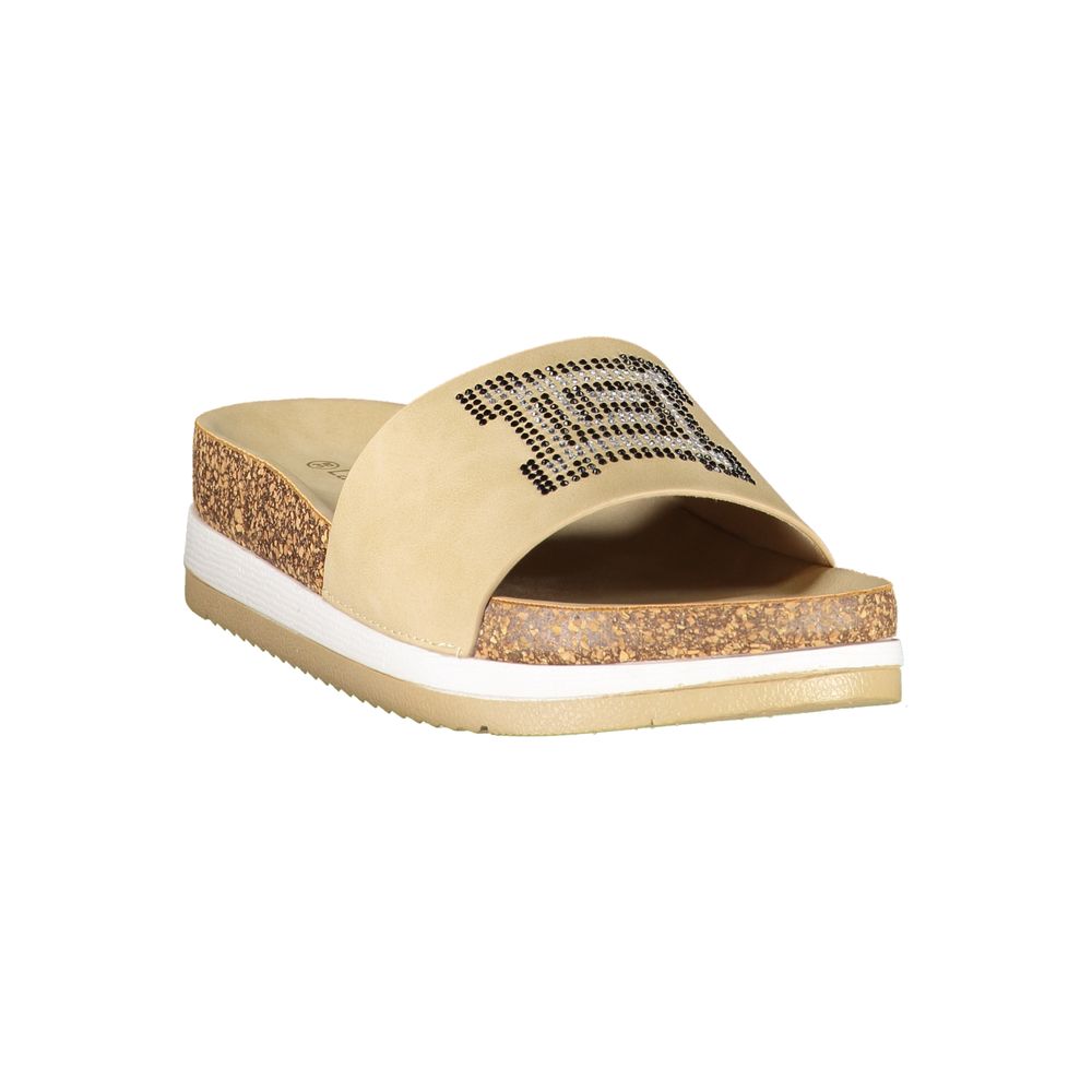 Female model wearing Laura Biagiotti beige polyurethane women's slipper with a warm beige upper, effortless slip-on silhouette, and refined Italian craftsmanship, captured mid-step in a casual lifestyle pose showcasing the slipper's relaxed neutral charm and understated everyday luxury.