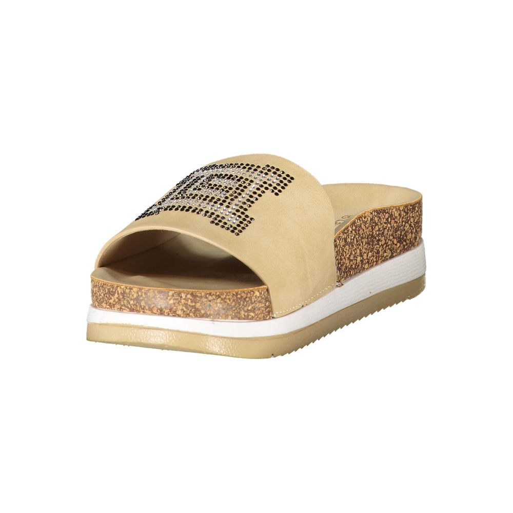 Female model wearing Laura Biagiotti beige polyurethane women's slipper with a warm beige upper, effortless slip-on silhouette, and refined Italian craftsmanship, captured mid-step in a casual lifestyle pose showcasing the slipper's relaxed neutral charm and understated everyday luxury.