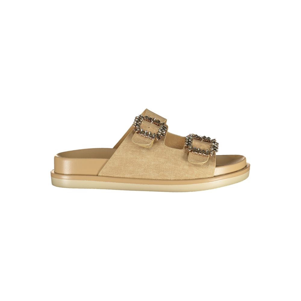 Female model wearing Laura Biagiotti gold polyurethane women's sandal with two wide shimmer straps featuring ornate jewelled buckle embellishments, a cushioned flatform sole, and refined Italian craftsmanship, captured mid-step in a casual lifestyle pose showcasing the sandal's glamorous golden opulence and effortless designer luxury.